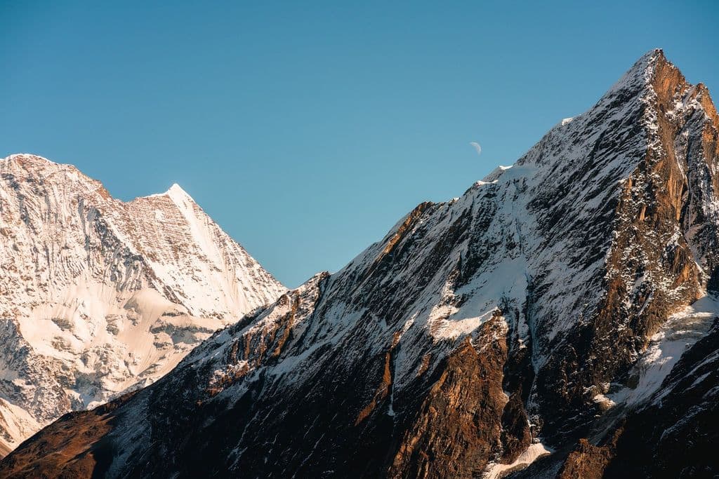 The sun shines on two mountain tops.