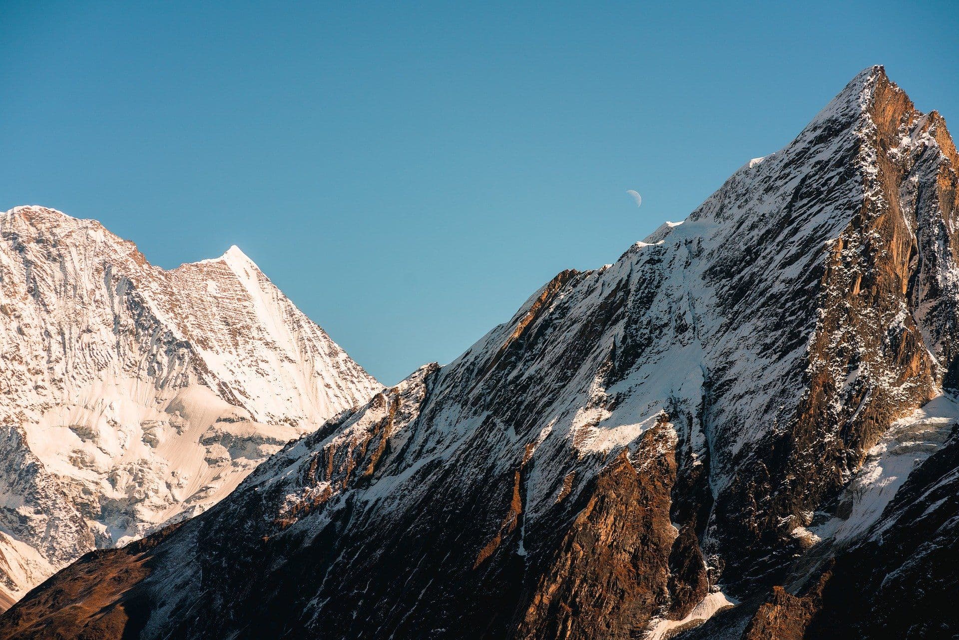 The sun shines on two mountain tops.